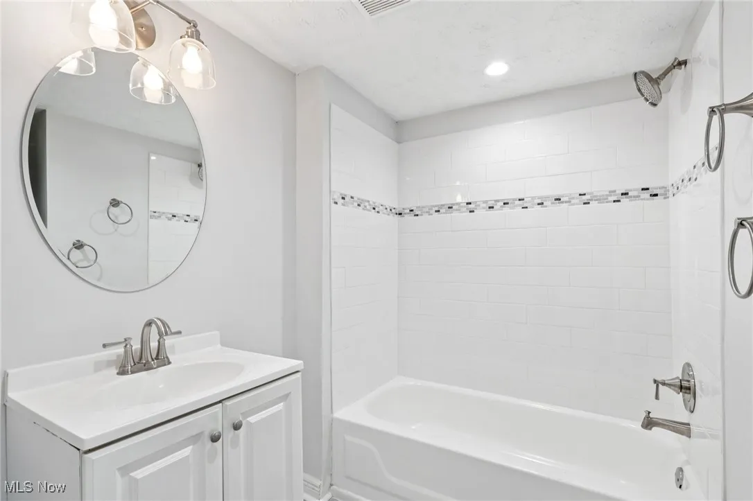 Bathroom featuring shower / bathtub combination, vanity, recessed lighting, and a textured ceiling