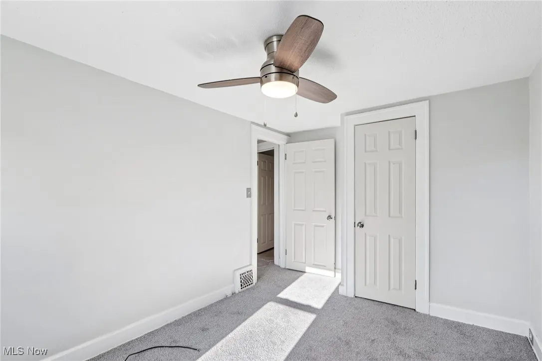 Unfurnished bedroom with carpet, a closet, and ceiling fan