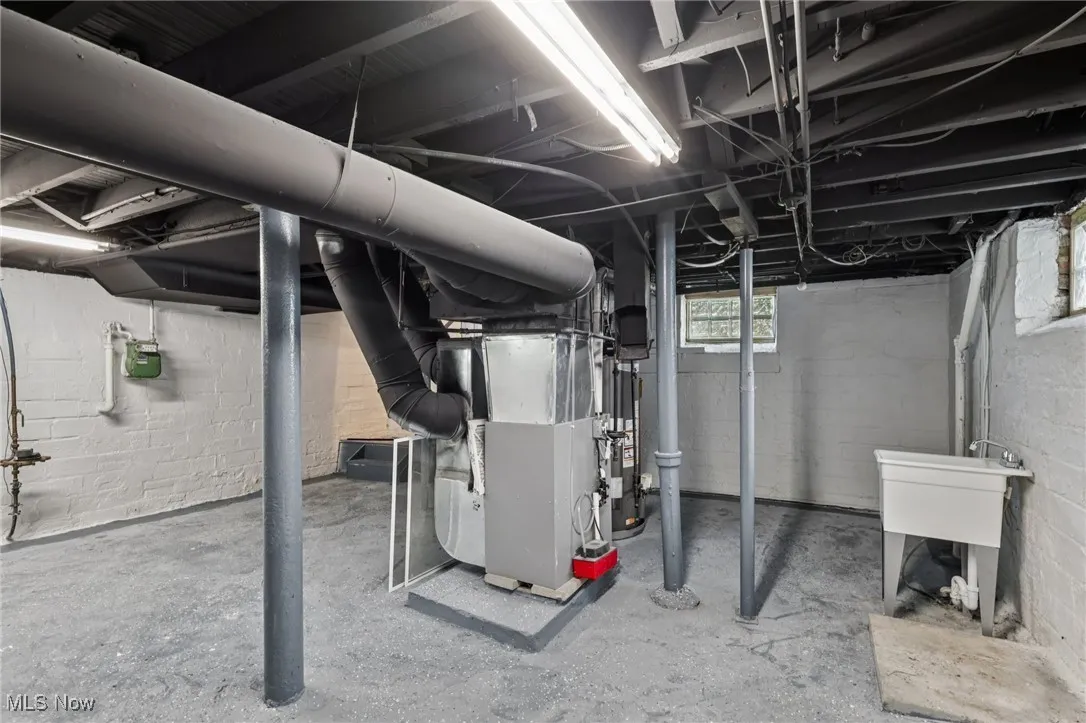 Basement featuring heating unit and water heater