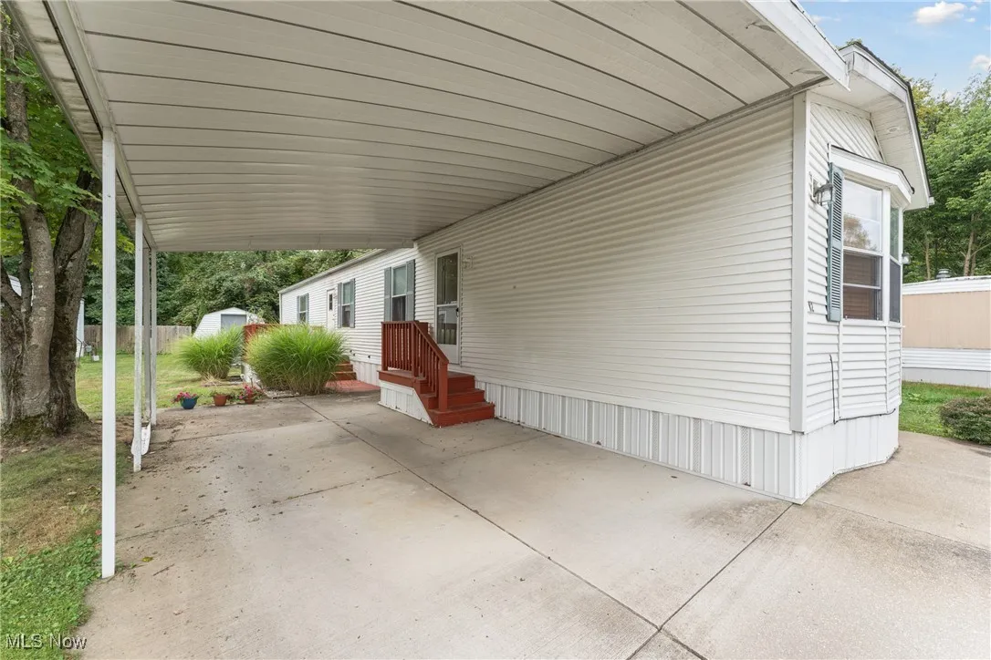 View of patio featuring an attached carport and a storage unit