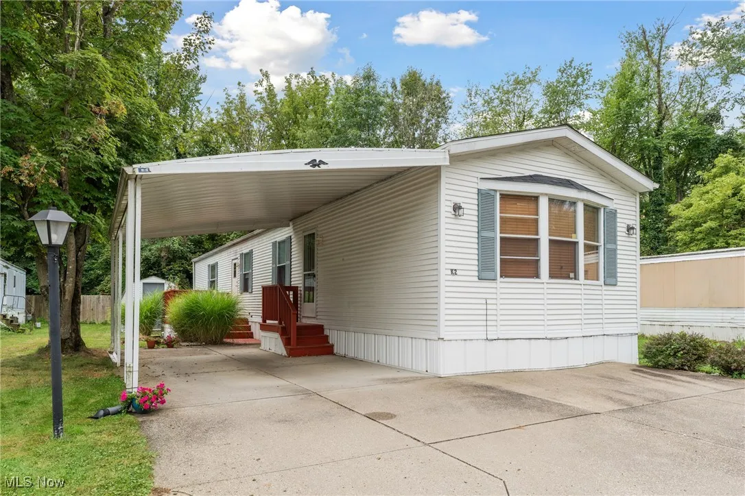 Manufactured / mobile home featuring driveway and a carport