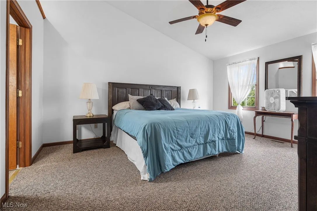 Bedroom featuring carpet floors, high vaulted ceiling, and ceiling fan