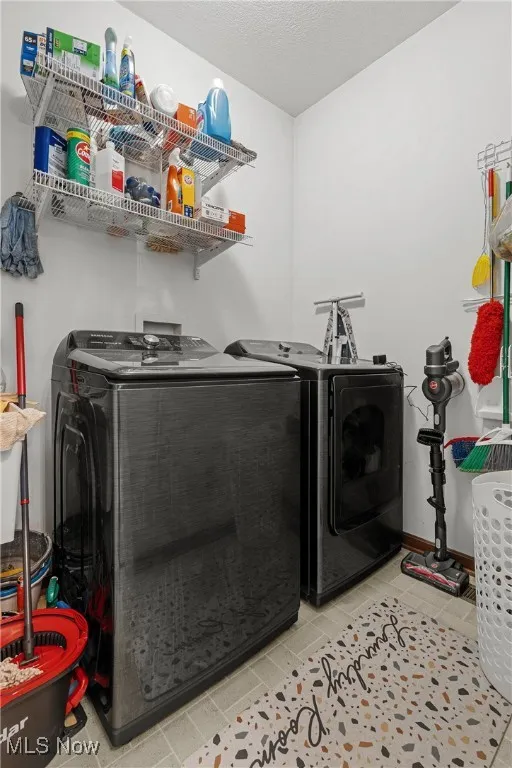 Washroom with washing machine and dryer and a textured ceiling