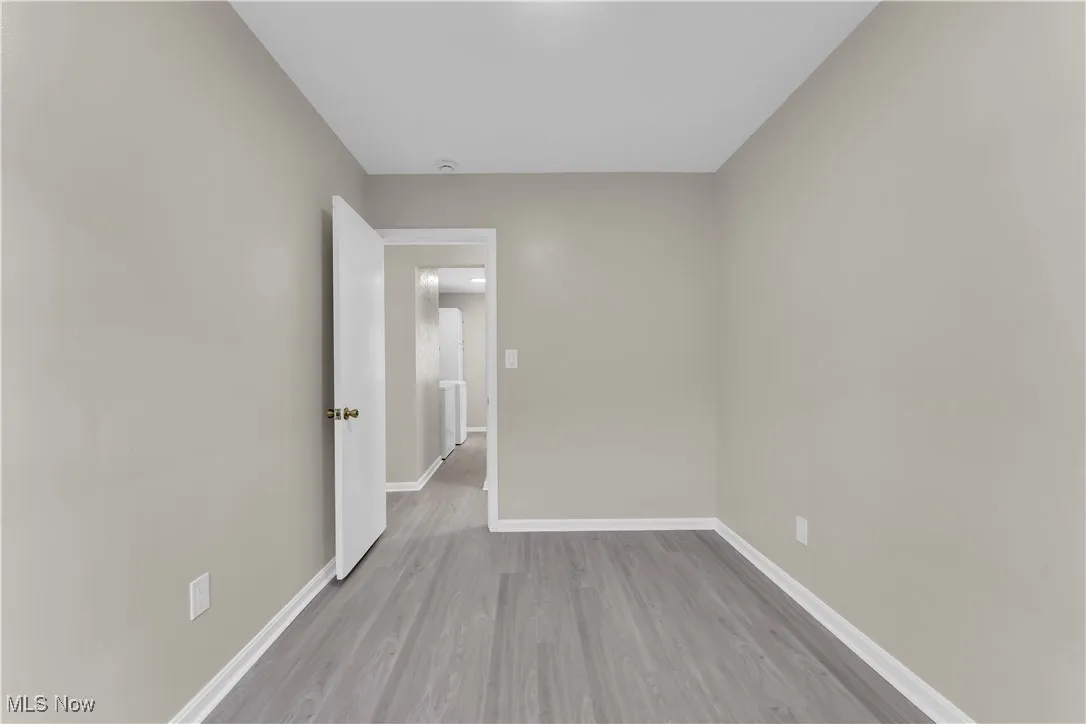 Spare room featuring light wood-type flooring and baseboards