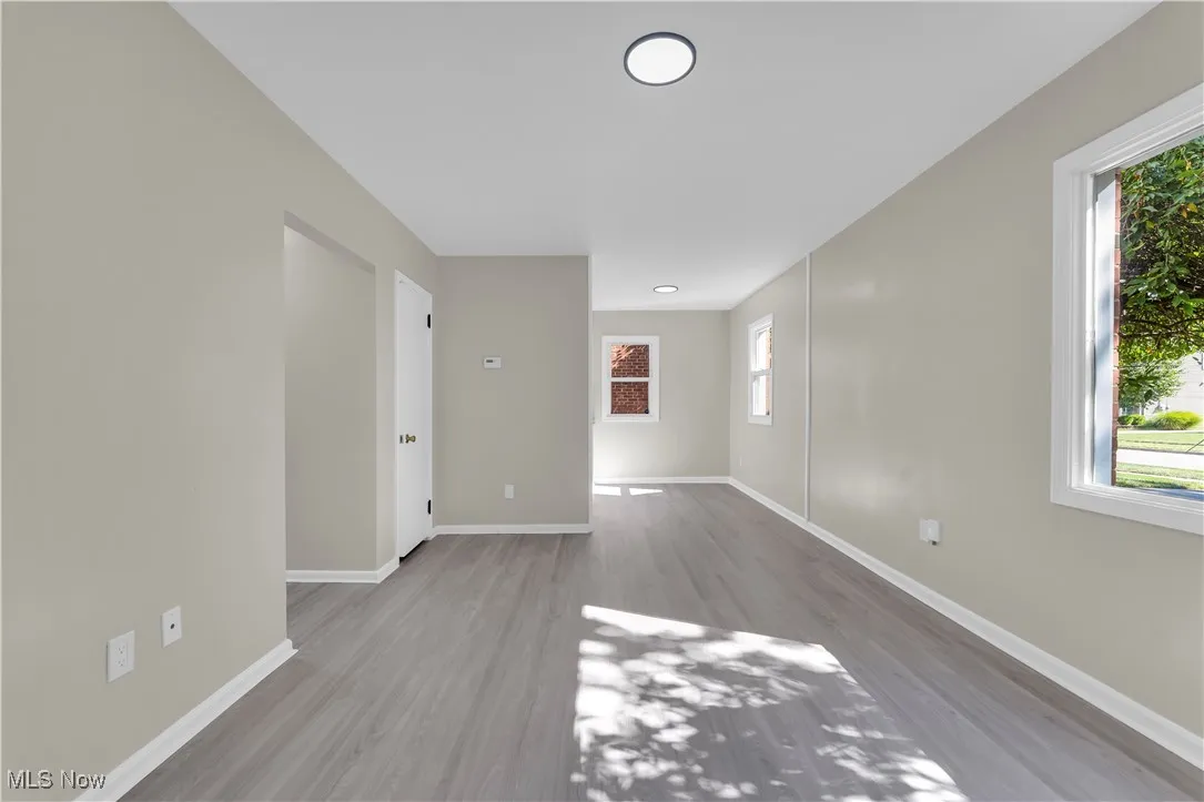 Unfurnished room featuring light wood finished floors and baseboards