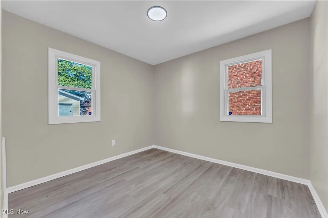 Spare room featuring light wood finished floors and baseboards