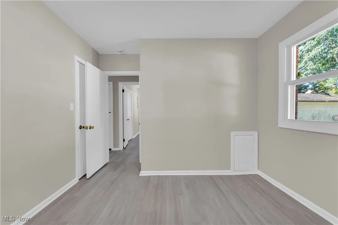 Unfurnished room with light wood-style flooring and baseboards