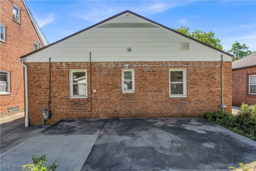 Rear view of house featuring a patio and brick siding