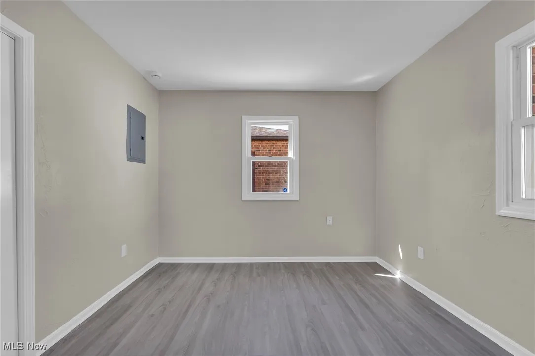 Spare room featuring wood finished floors and electric panel