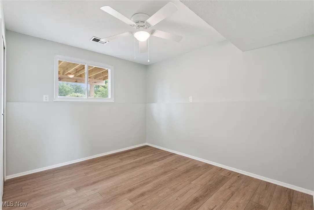 Spare room with wood finished floors and a ceiling fan