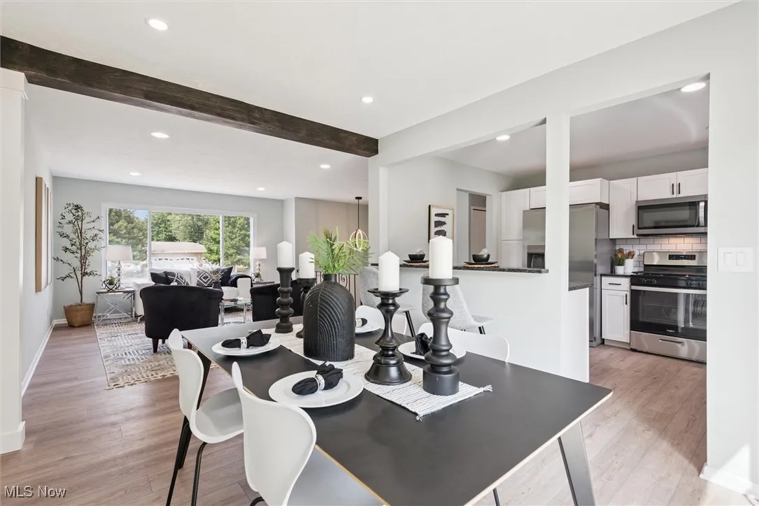 Dining room featuring beamed ceiling, recessed lighting, and light wood-style floors