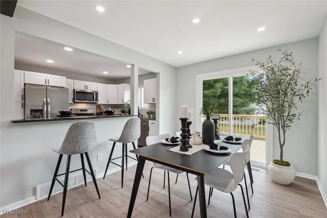 Dining space with light wood-style floors and recessed lighting