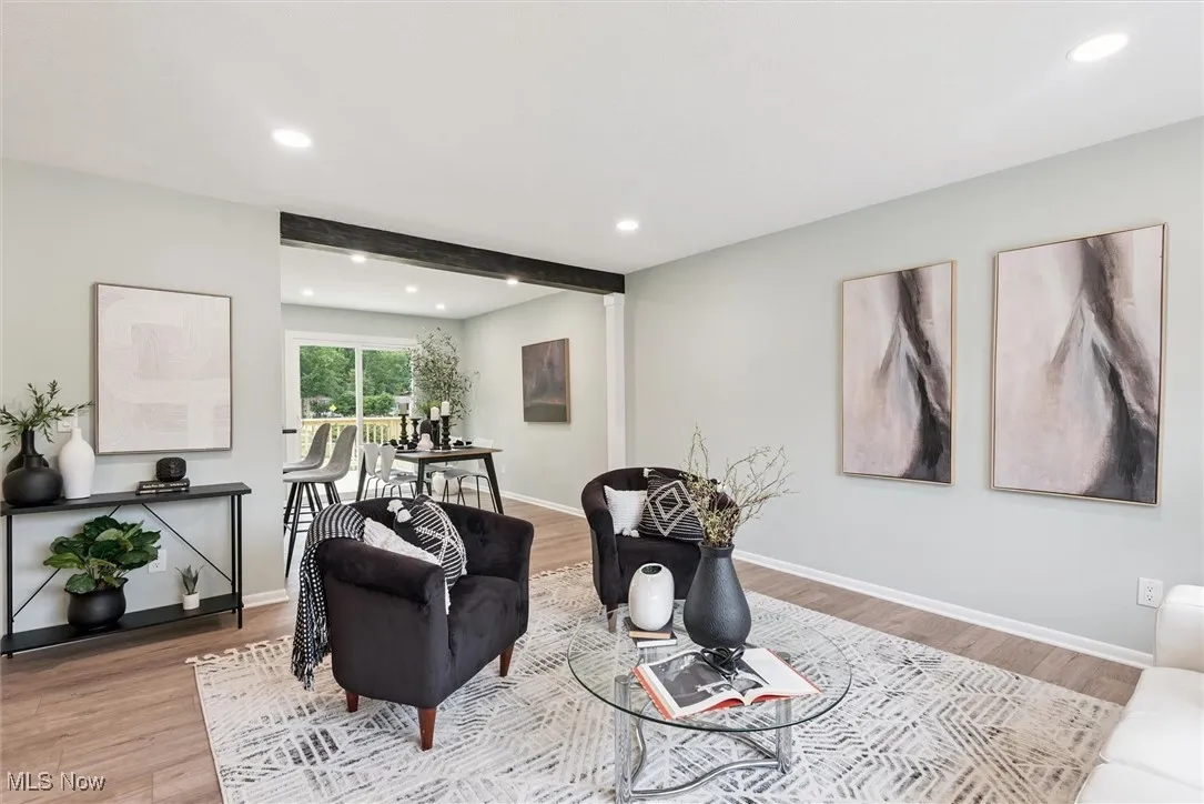 Living area with recessed lighting, wood finished floors, and beamed ceiling