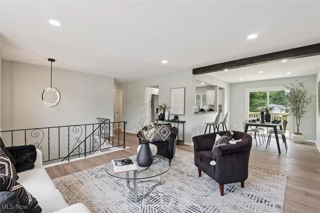 Living area featuring recessed lighting, beam ceiling, and wood finished floors