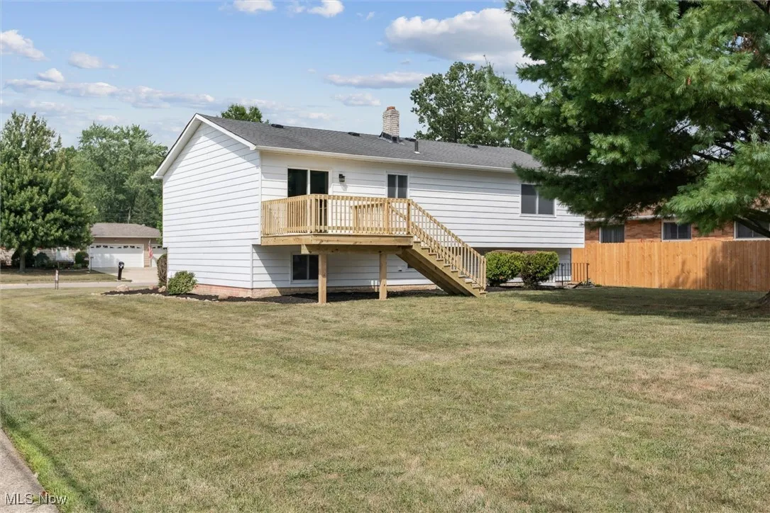 Back of property featuring stairway, a deck, and a chimney