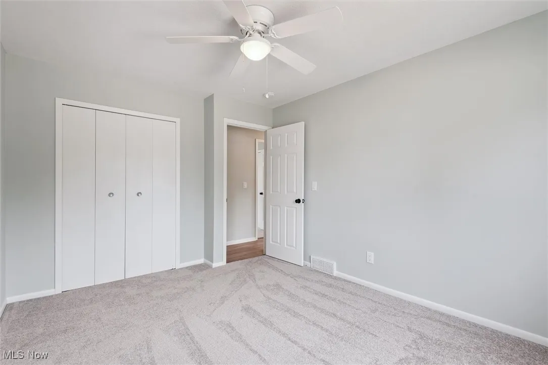 Unfurnished bedroom featuring carpet, ceiling fan, and a closet