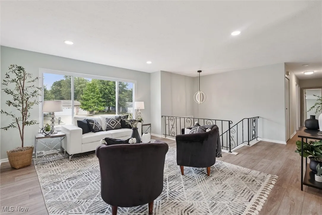 Living room with light wood-style flooring and recessed lighting