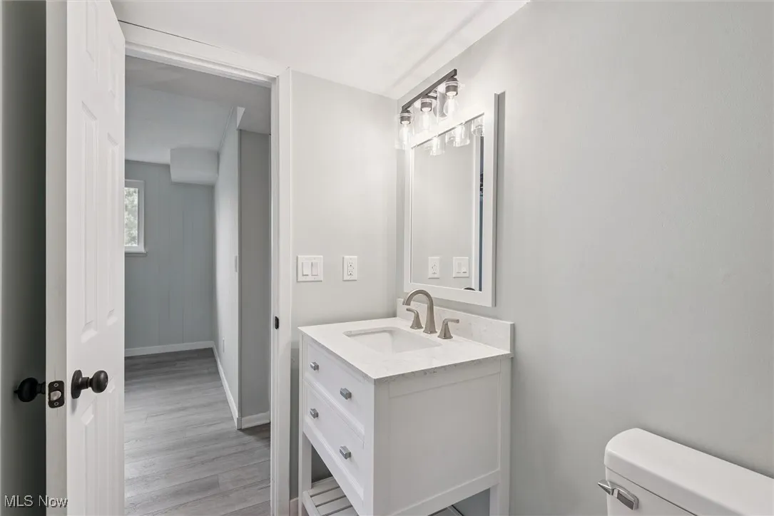 Half bath featuring vanity and light wood-style floors