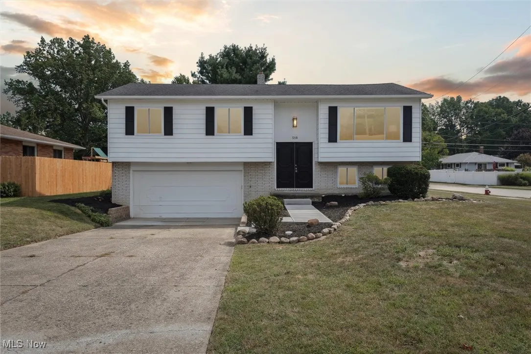 Bi-level home featuring brick siding, concrete driveway, and a garage