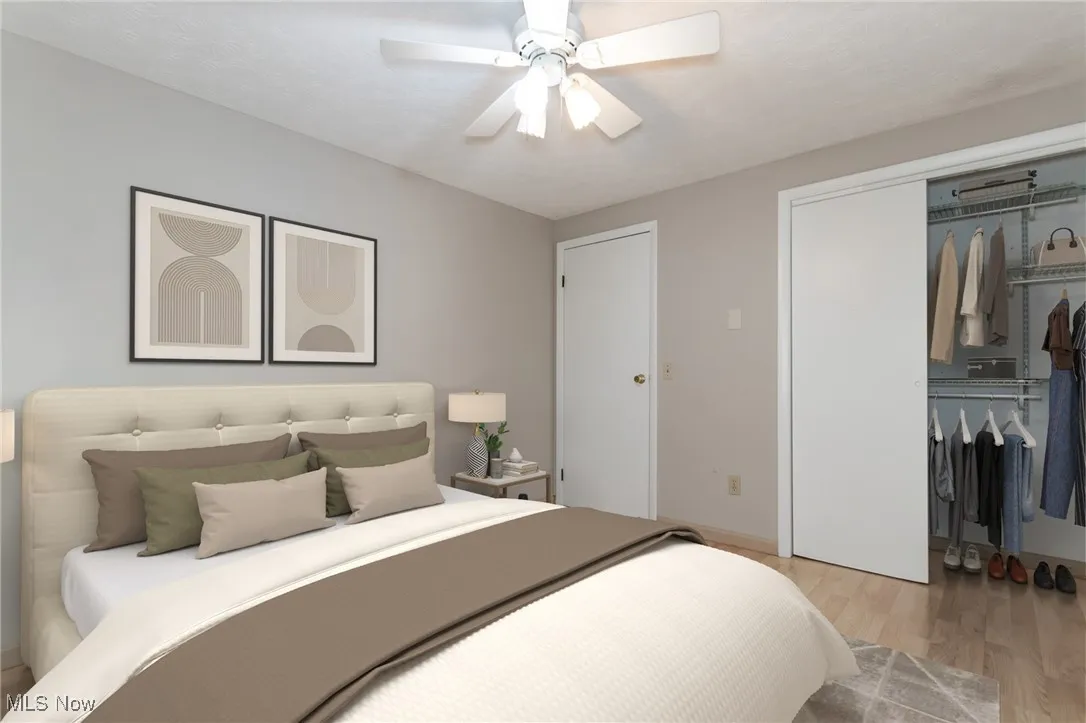 Bedroom with light wood finished floors, a closet, and a ceiling fan