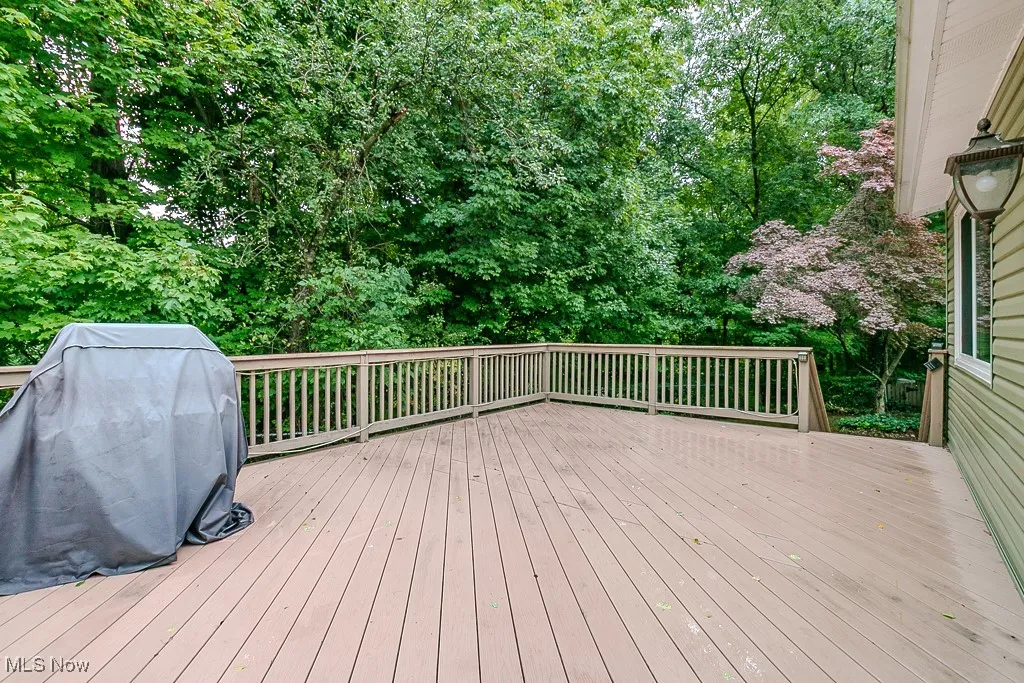 Wooden deck featuring grilling area and view of scattered trees