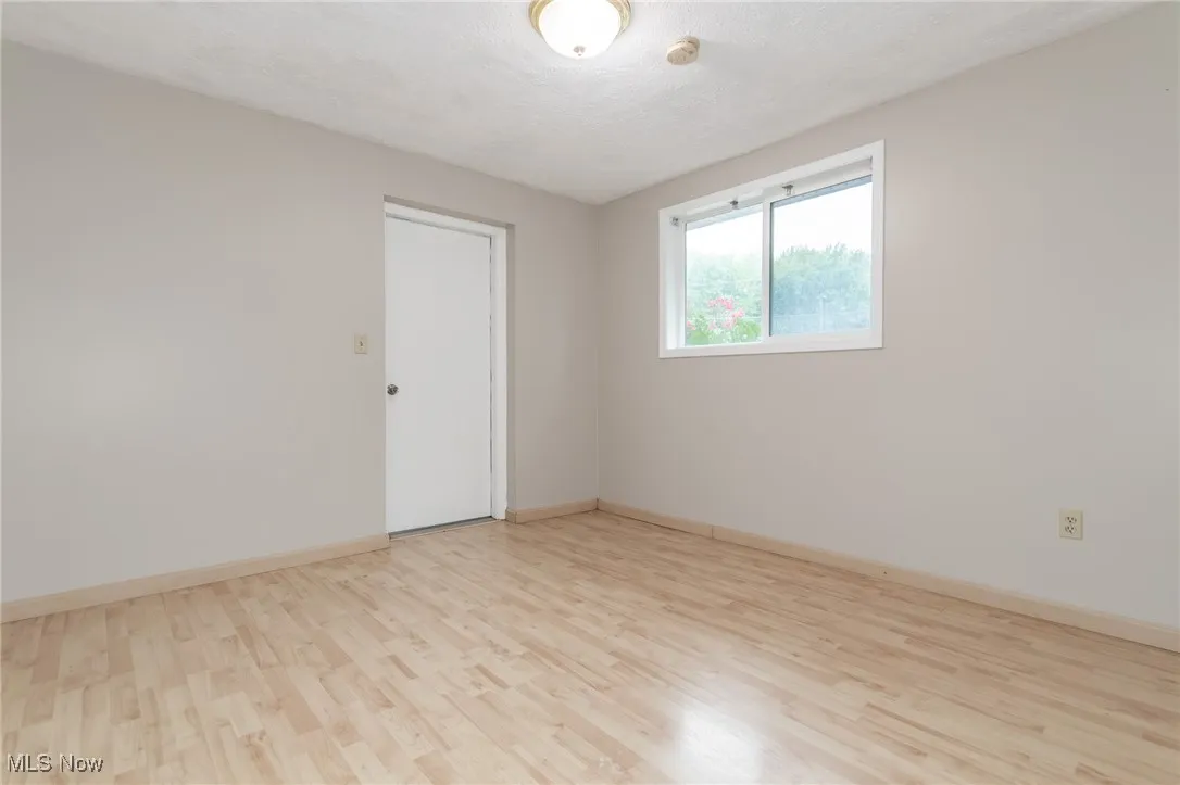 Unfurnished room with light wood-type flooring and a textured ceiling