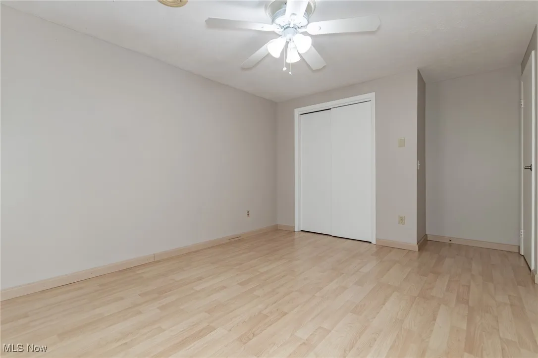 Unfurnished bedroom with light wood finished floors, a ceiling fan, and a closet