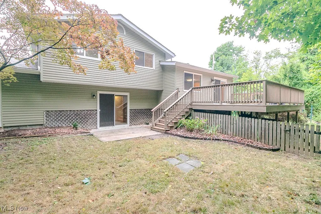 Back of house with stairway, a patio area, and a deck