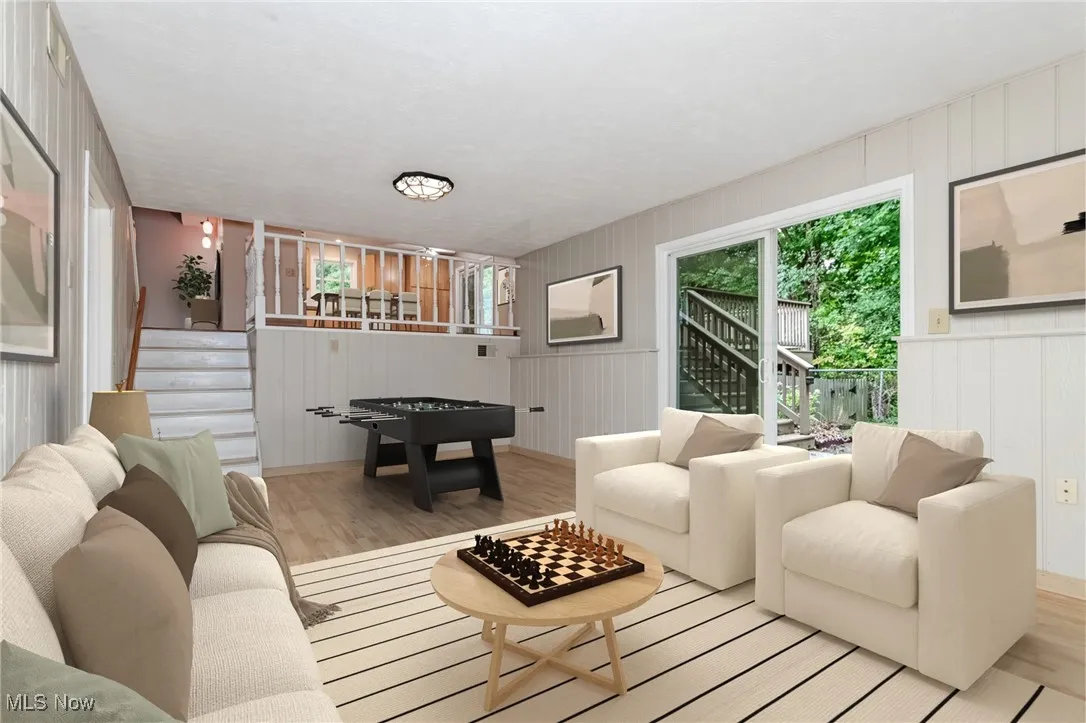 Living room featuring stairway, wood finished floors, plenty of natural light, and wooden walls