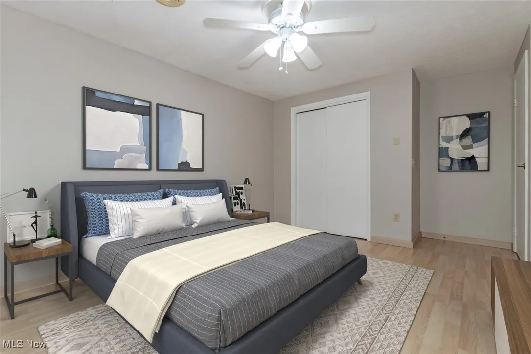 Bedroom featuring light wood finished floors, a ceiling fan, and a closet