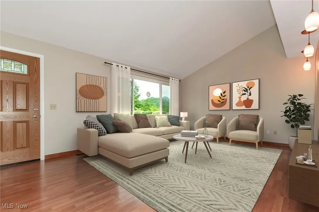 Living area with light wood finished floors and high vaulted ceiling