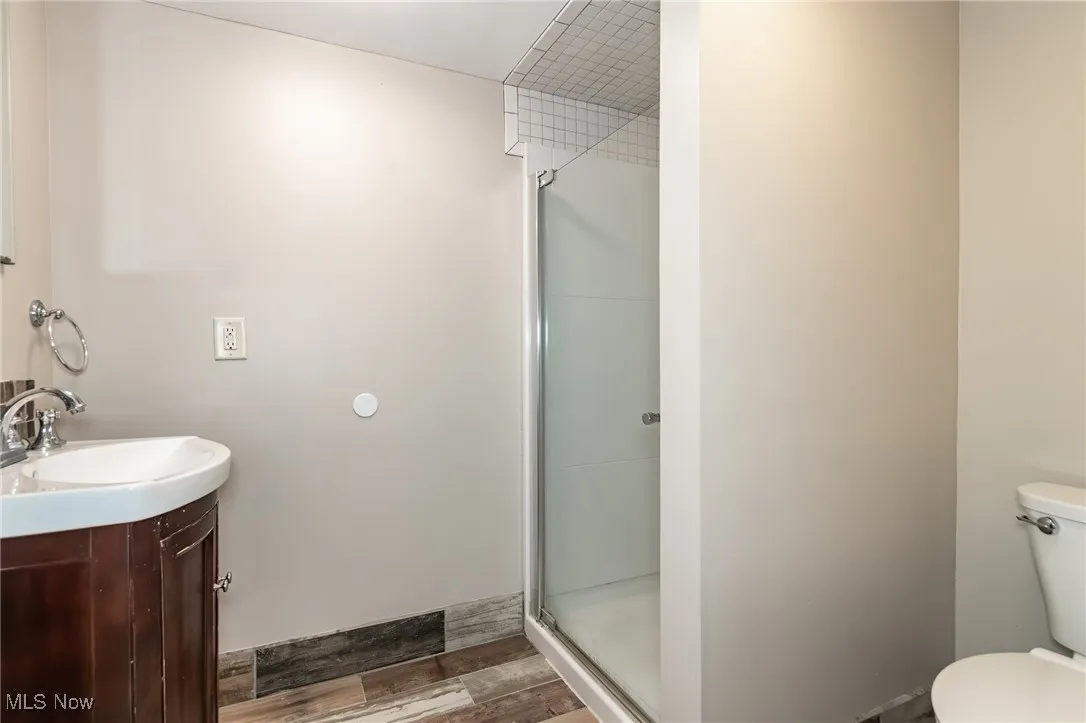Bathroom featuring vanity, a shower stall, and wood finished floors
