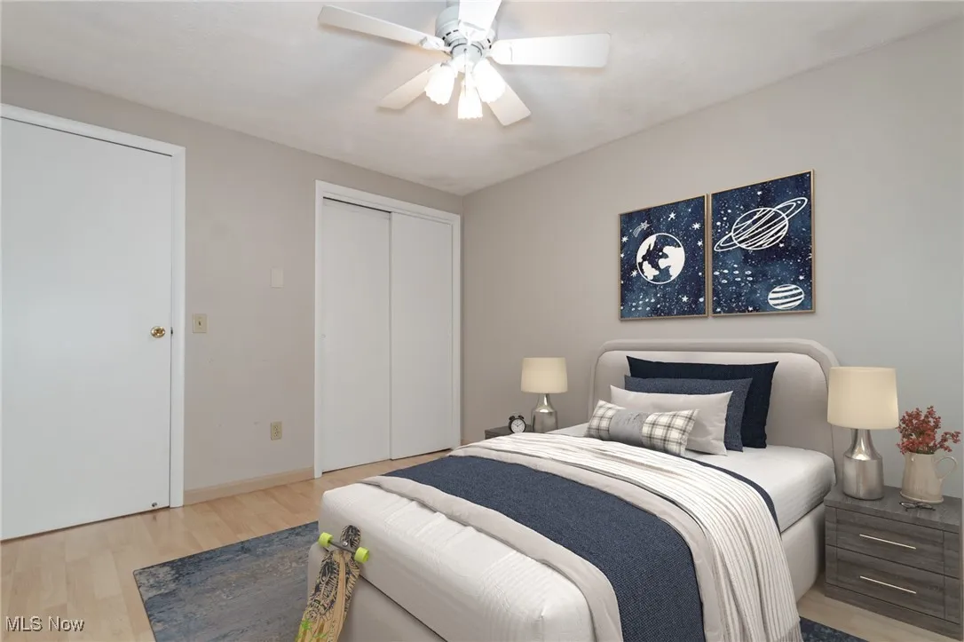 Bedroom featuring light wood-type flooring, a ceiling fan, and a closet