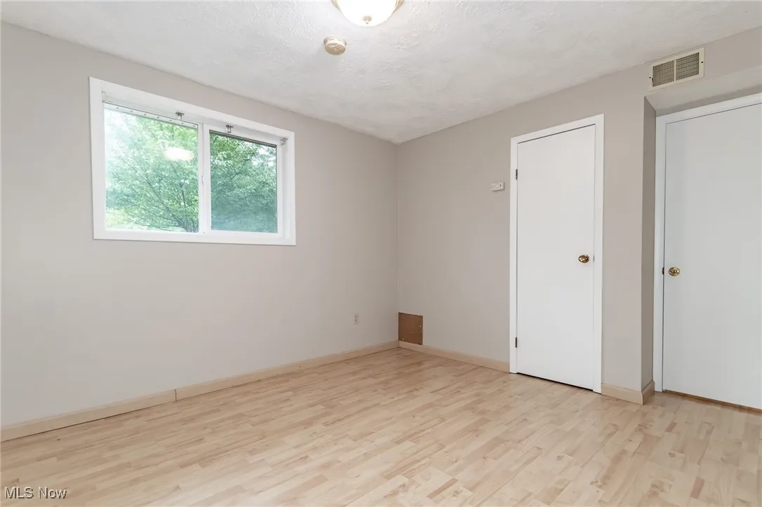 Unfurnished room featuring light wood-style floors and a textured ceiling