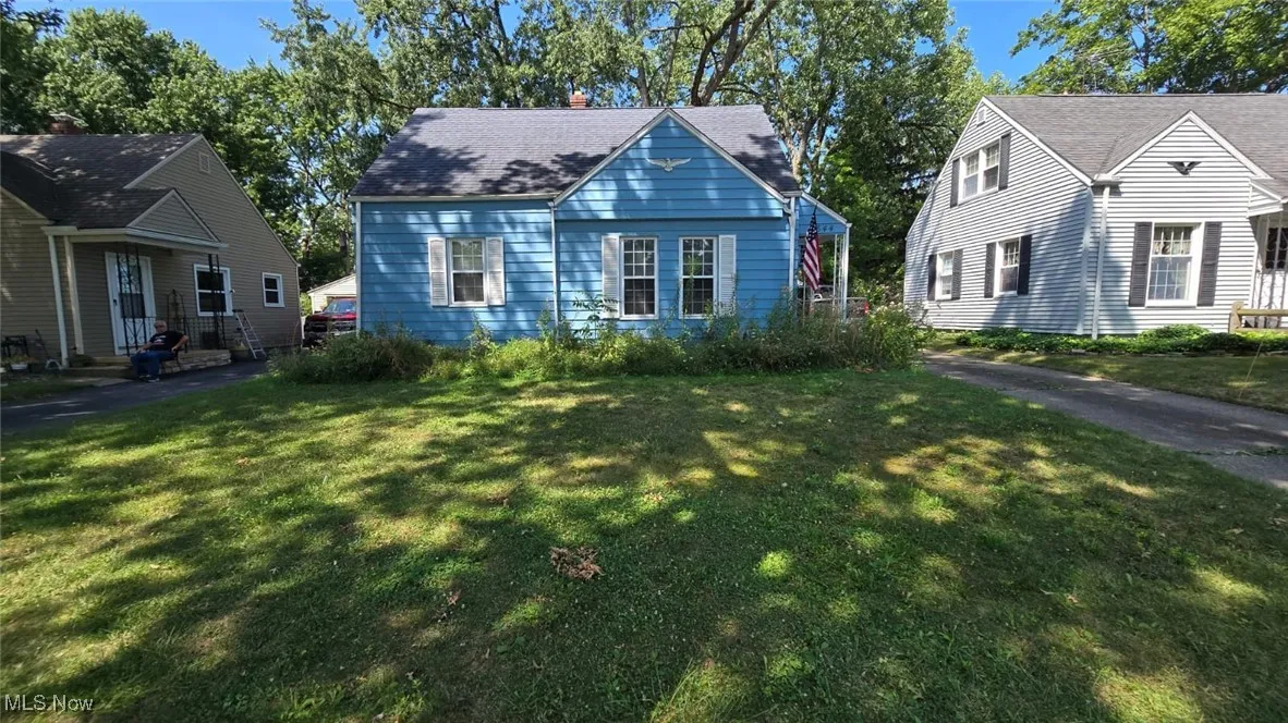 View of front of house with a front lawn and roof with shingles