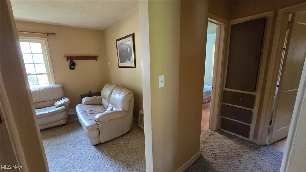 Hall featuring baseboards and carpet