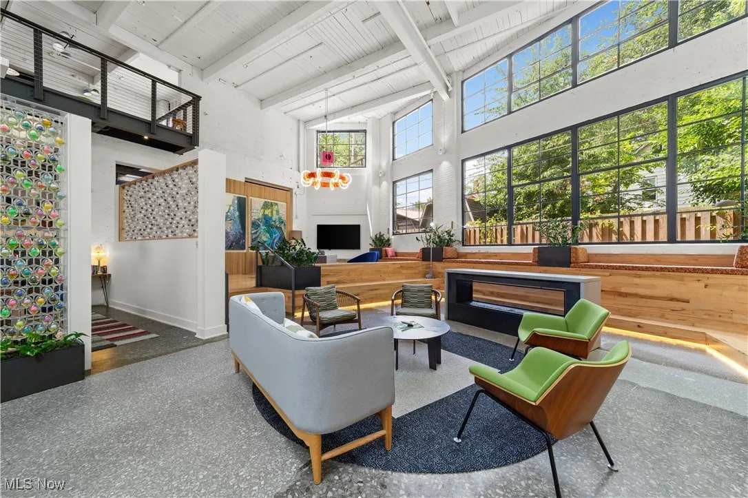 Comfortable lounge seating in community living area with a fireplace and oversized windows
