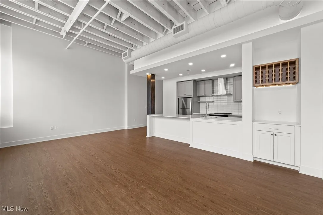 Living room and kitchen with high ceilings and exposed beams
