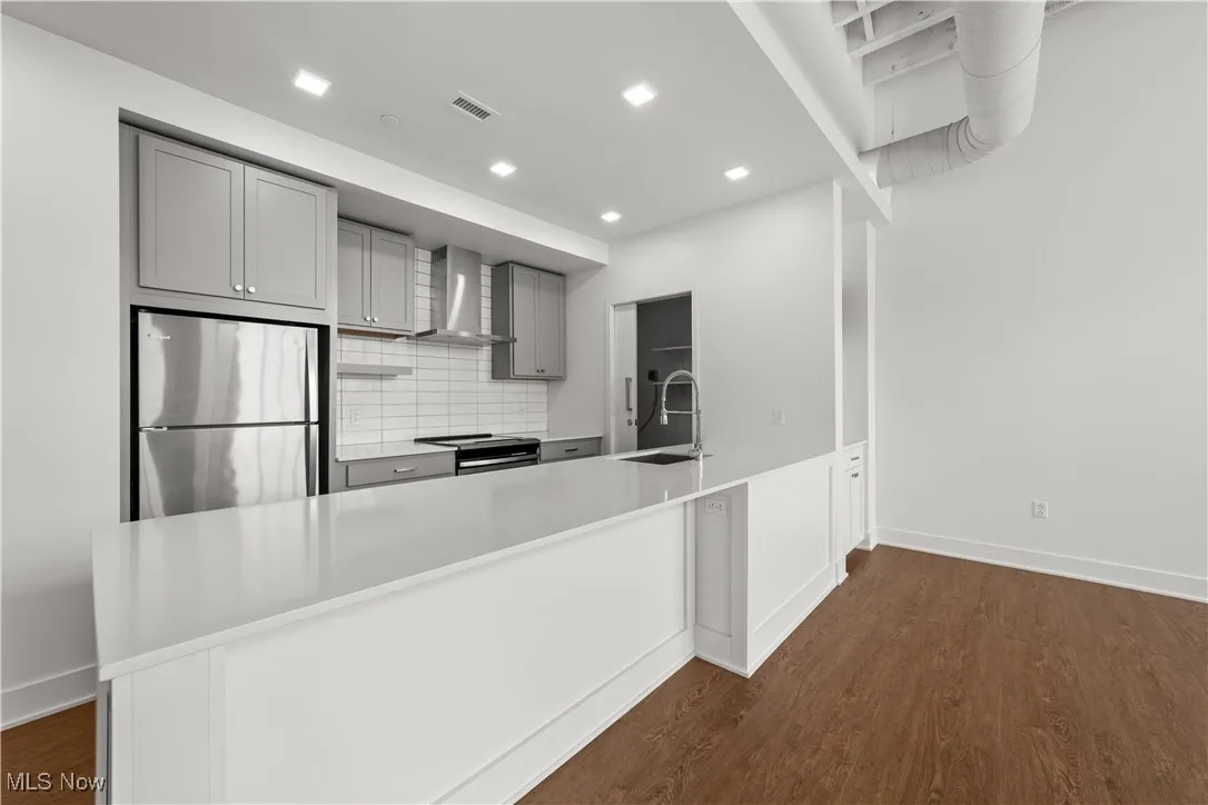 Kitchen with stainless steel appliances and large island with space for 3 to 4 counter stools
