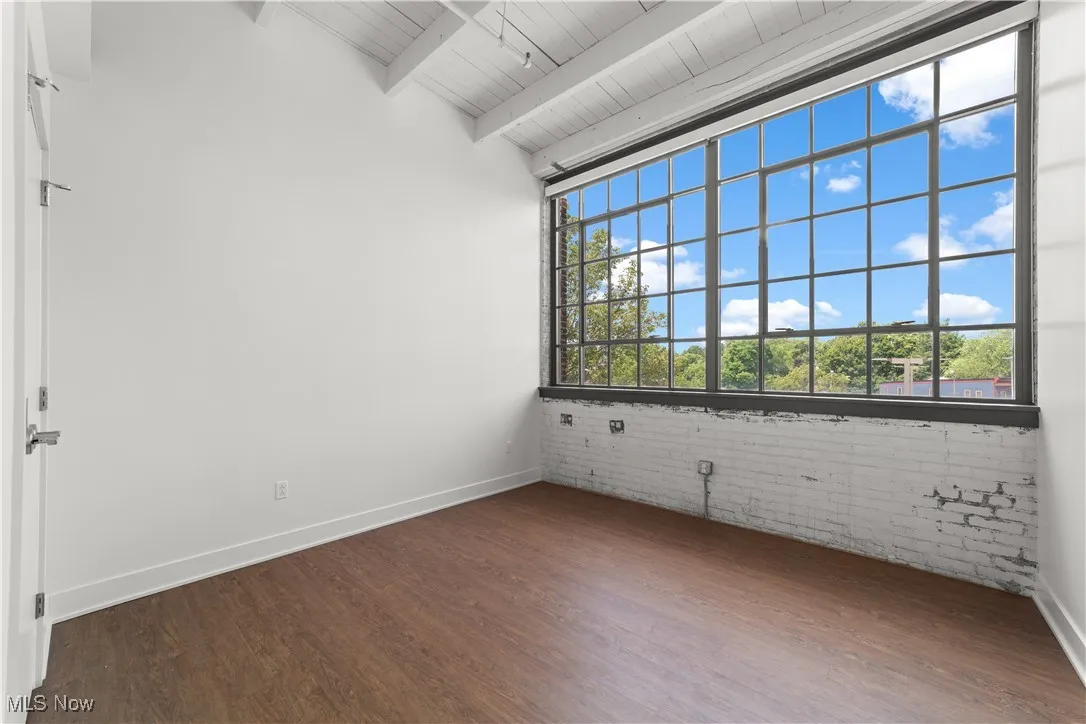 Sunny bedroom with ten foot tall industrial style windows 
