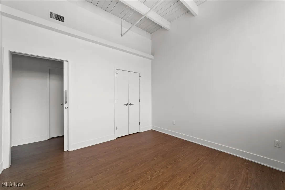 Bedroom with wood look flooring and closet storage
