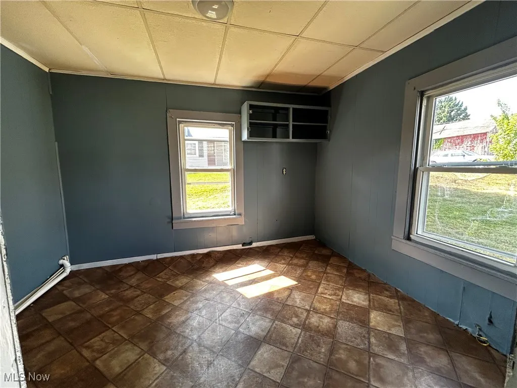 Unfurnished room with wood walls and dark stone finish flooring