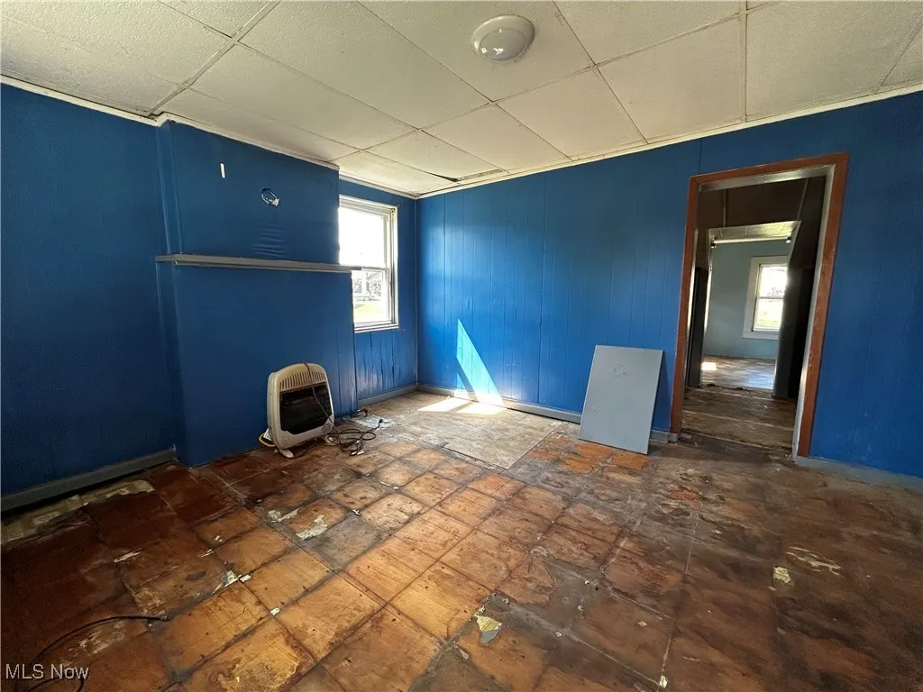 Spare room featuring a drop ceiling and heating unit