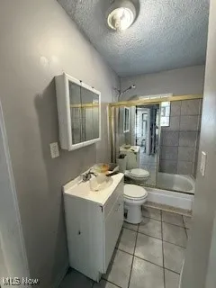 Bathroom with a stall shower, vanity, light tile patterned flooring, and a textured ceiling