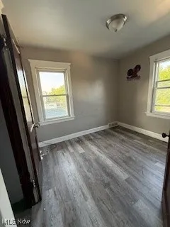 Unfurnished bedroom featuring dark wood finished floors and baseboards