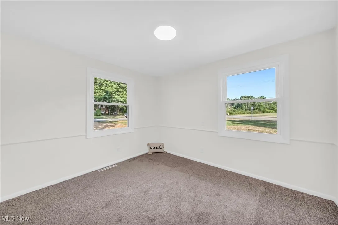 Carpeted spare room with baseboards