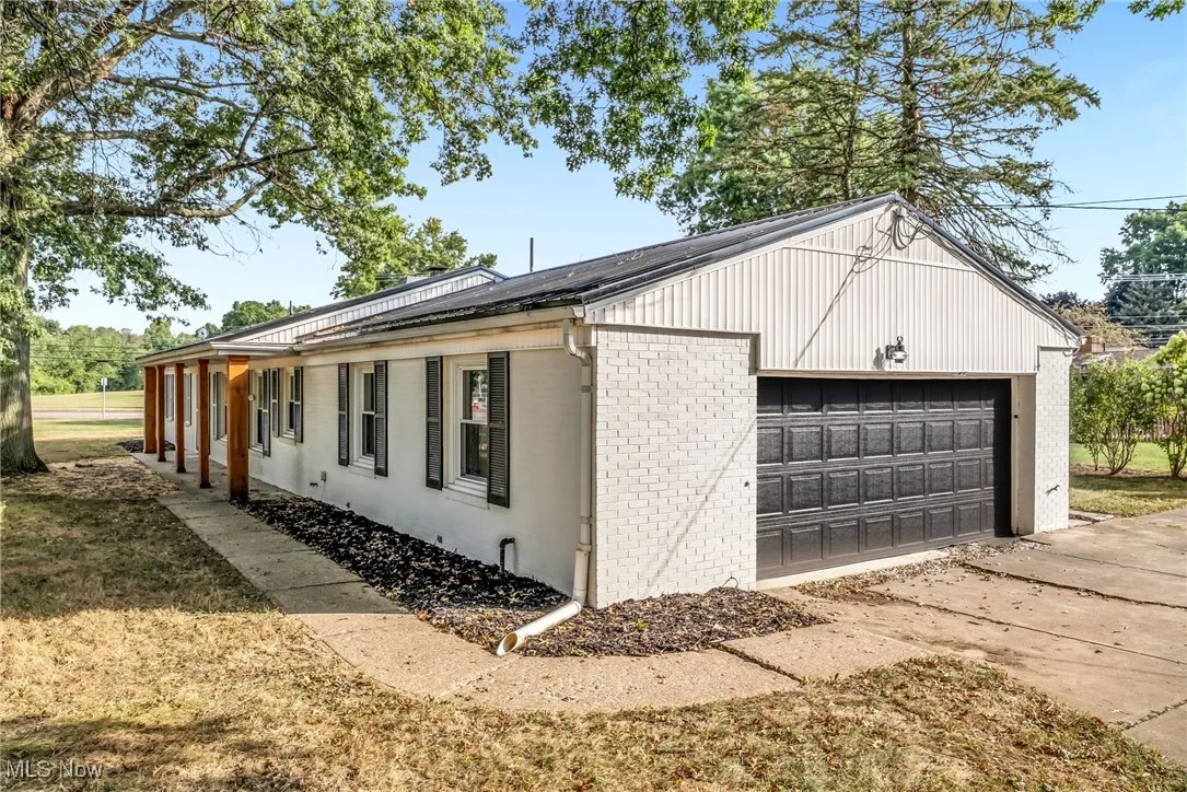 View of side of home with brick siding and a garage