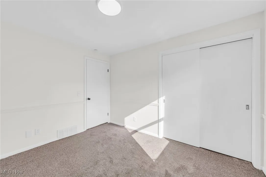 Unfurnished bedroom with carpet and a closet