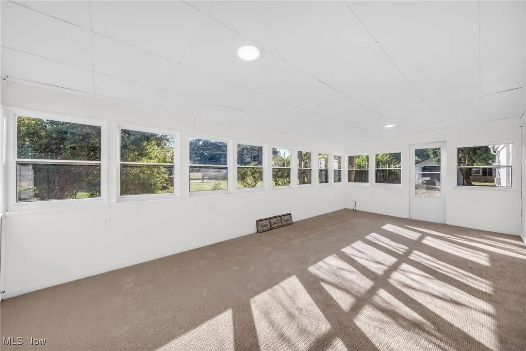 Unfurnished sunroom with carpet flooring