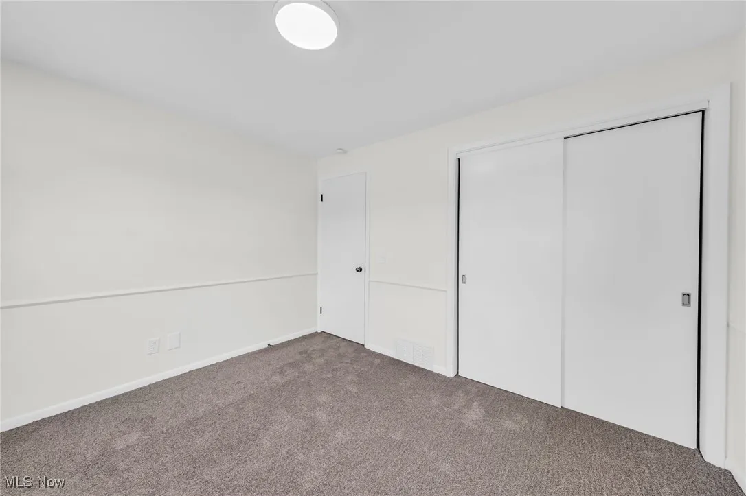 Unfurnished bedroom with a closet and carpet flooring